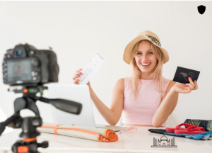 A girl sitting on a chair in front of a camera, holding a cheque.